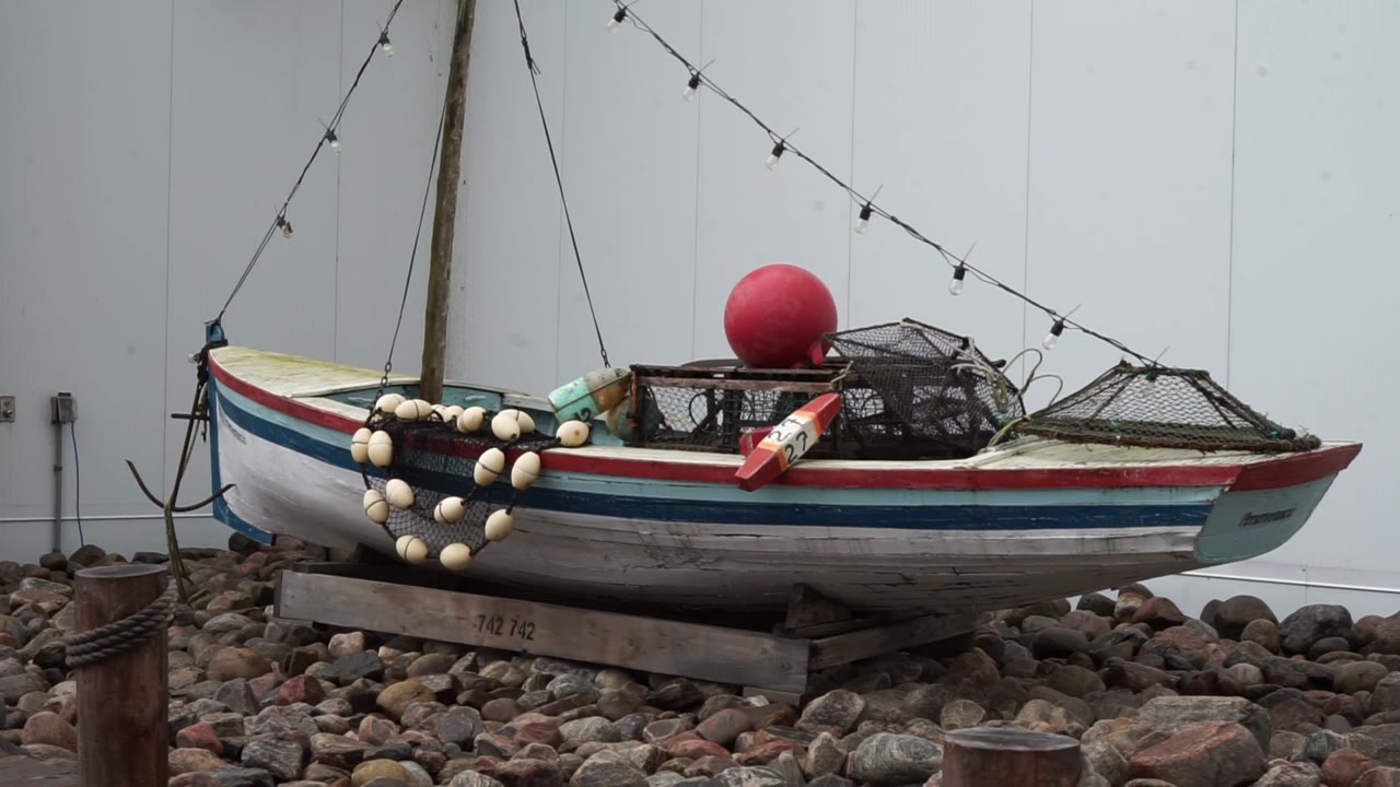 Une barque de pêche décorative devant le commerce