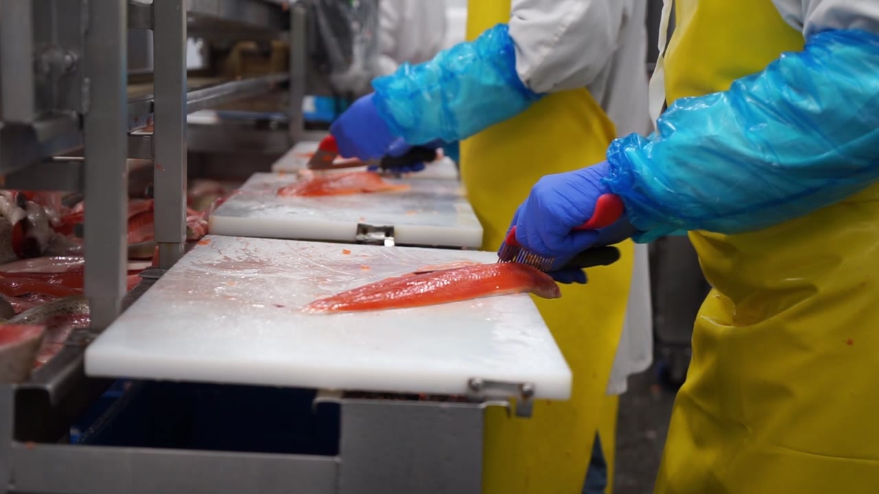 Un employé prépare un filet de poisson